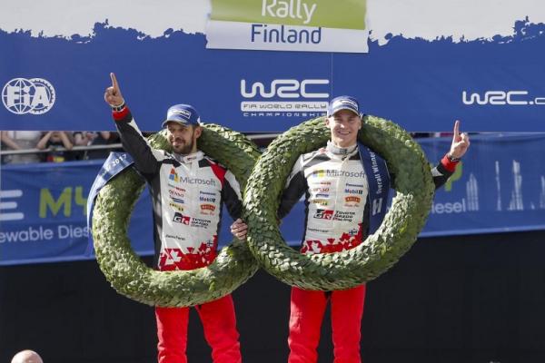 Essapekka Lappi dan navigator Janne Ferm dengan penuh kegembiraan di podium juara