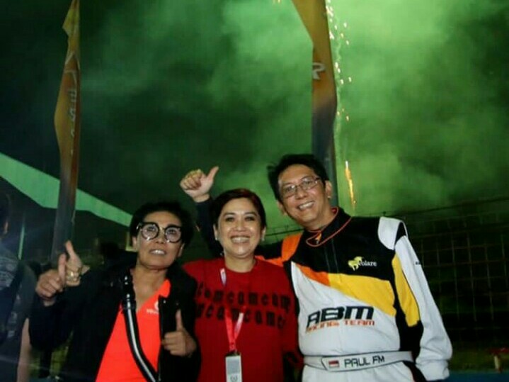 Kiri - kanan : Lola Moenek, Vivi Montolalu dan Paul Montolalu dengan latar belakang kembang api di night race ISSOM. (foto : abm)