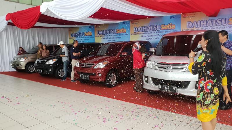 Pemilik mobil rekondisi Daihatsu di Surabaya mengekspresikan kegembiraan bertemu mobilnya dalam kondisi seperti baru. (foto: windy) 