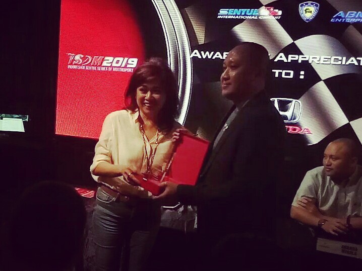 Vivi Montolalu saat memberikan plakat kepada Alvin Bahar dari Honda Racing Indonesia. (foto : bs)