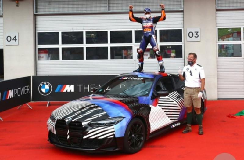 Miguel Oliveira berdiri di atas mobil BMW M4 hadiah atas kemenangannya di MotoGP Styria