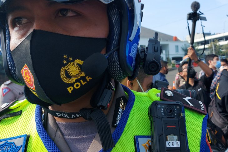 Petugas kepolisian menggunakan kamera ETLE Mobile di seragamnya untuk merekam pelanggaran lalu lintas pengguna kendaraan di Jakarta