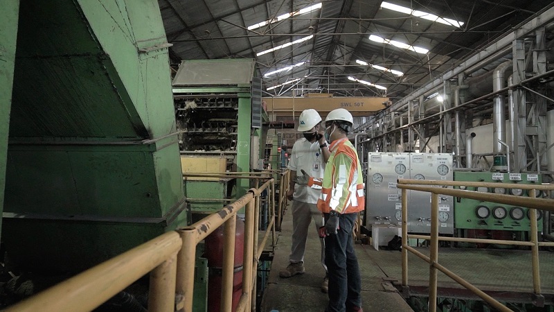 Operator teknis lubrikasi Shell memeriksa mesin dalam sebuah pabrik