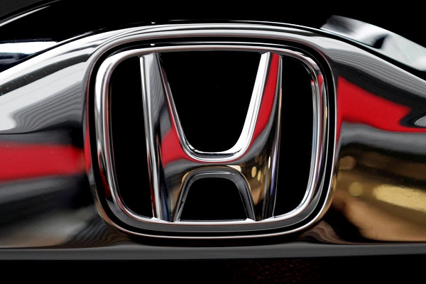Ilustrasi logo Honda krom pada sebuah unit mobil 