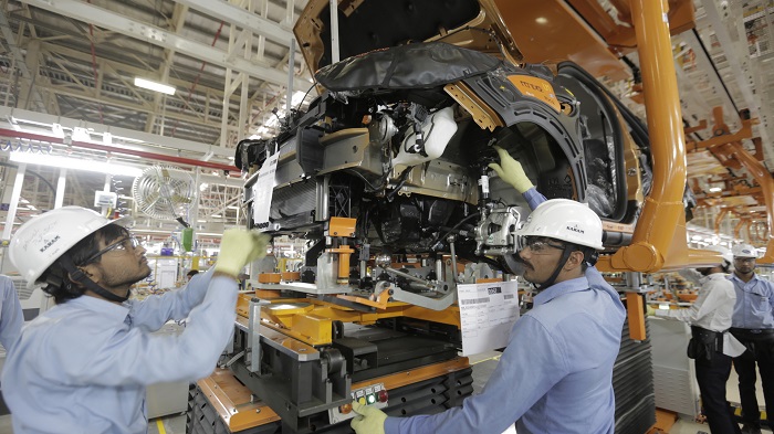 Ilustrasi para mekanik merakit mobil Ford di sebuah pabrik di India
