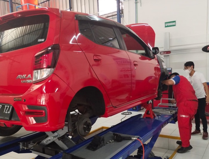 Ilustrasi teknisi bengkel Astra Otoservice yang sedang memperbaiki mobil konsumen