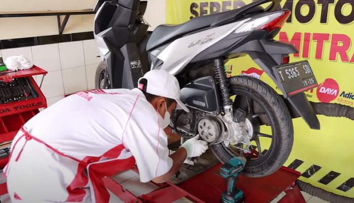 Teknisi Honda sementara memperbaiki motor konsumen