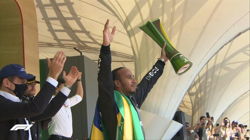 Mengusung bendera Brasil, Lewis Hamilton persembahkan kemenangannya buat alm Ayrton Senna sang legenda Brasil. (Foto: f1)