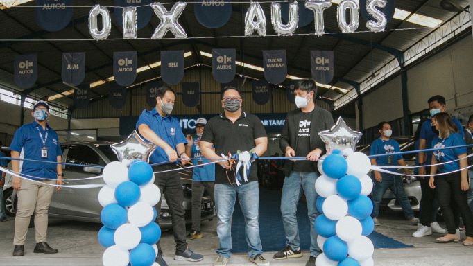 Petinggi OLX Autos menggunting pita pada pembukaan outlet baru OLX Autos di Surabaya