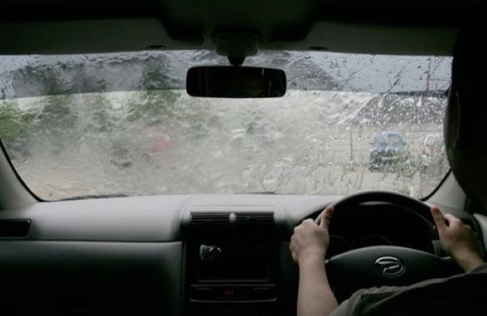 Mengemudi mobil dalam kondisi hujan dengan jarak pandang yang terbatas, harus tetap waspada