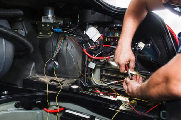 Teknisi yang memperbaiki relay mobil pada sistem kelistrikan, biar kendaraan tetap lancar jaya
