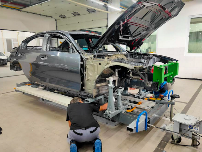 Teknisi BMW Approved Bodyshop sementara memperbaiki kerusakan pada mobil BMW