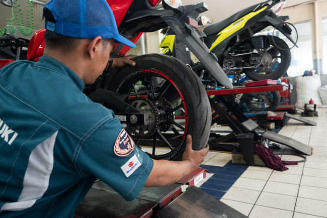 Mekanik Suzuki melakukan perawatan motor konsumen di bengkel resmi Suzuki