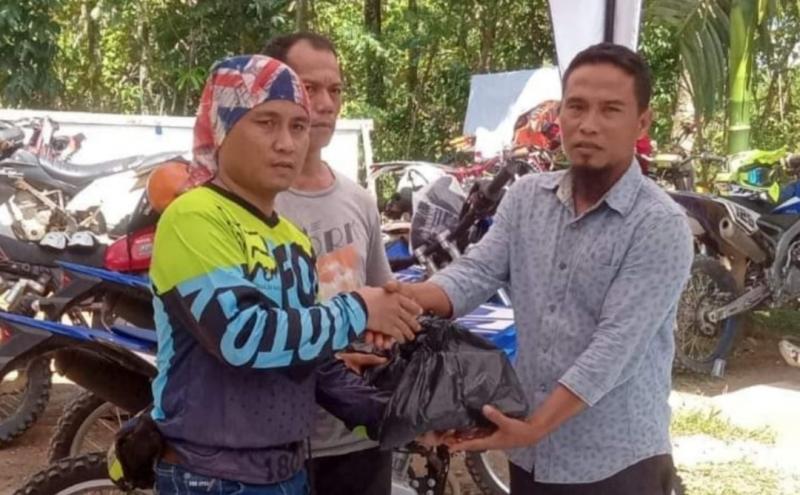 Alex Kurniawan menyerahkan paket sembako kepada warga sekitar. (foto : ende)