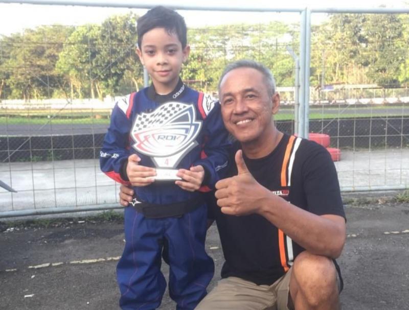 Syabil Umar Basalamah (6 tahun) tersenyum bangga dengan trofi juara 4 di tangan, bersama om Dicky Setiawan chief mekanik Delta Garage Kart Racing Team 