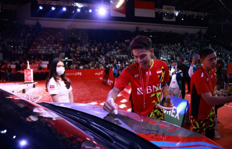 Pebulutangkis Indonesia membubuhkan tanda tangannya di mobil Daihatsu yang memang didispaly di arena turnamen bulutangkis International Daihatsu Indonesia Masters 2022 di Istora Senayan Jakarta