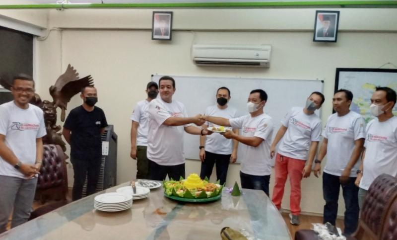 Haji Jimmy Syamsudin selaku owner Nusantara Racing Team memberikan potongan tumpeng kepada Memen Harianto CEO Suwarnadwipa Nusantara Circuit dan pembalap. (foto : bs)