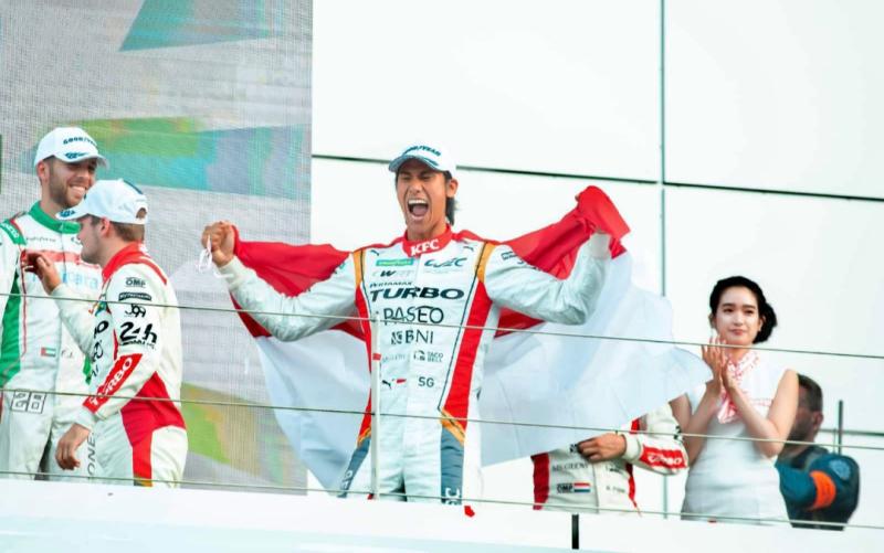 Pembalap terbaik Indonesia Sean Gelael meluapkan kegembiraan dan bentangkan bendera merah putih di podium juara 6 Hours of Fuji, Jepang, Minggu (11/9/2022)