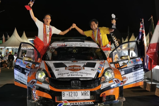 Ekspresi kegembiraan perally Achmad Deden dan co-driver Farrel HKR dengan trofi juara 1 kelas F1 di APRC Danau Toba Rally 2022. (foto: bs)