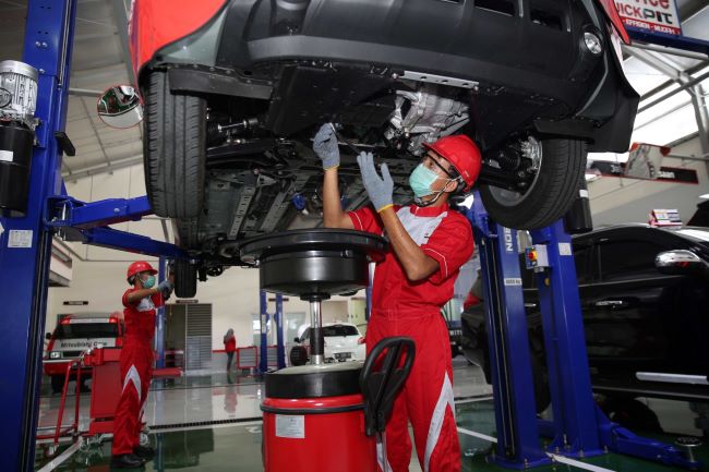 Teknisi Mitsubishi menangani perawatan mobil konsumen di dealer resminya