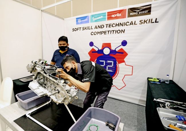 Seorang teknisi Piaggio Indonesia mengutak-atik mesin motor Piaggio dalam AFS Competition 2022