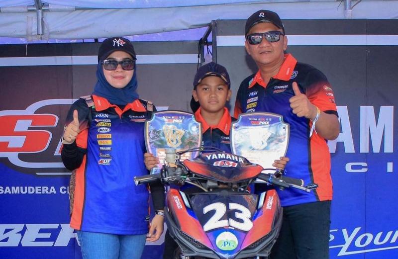 Sabian Fathul Ilmi dengan 2 trofi juara Oneprix 2023 Tasikmalaya, didampingi kedua orang tuanya yang tampak happy. (foto : yamaha aditama)