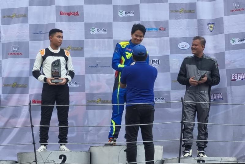 Rava Mahpud saat menerima trofi sebagai juara kelas 1500 Overall Kejurda IMI Jawa Barat dari Fredi Rostiawan Kabid Olahraga Mobil IMI Jawa Barat. (foto : budsan)