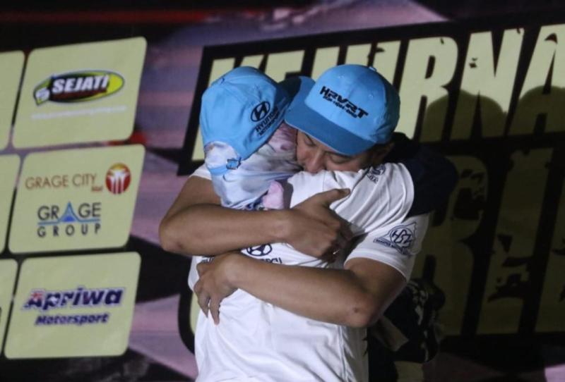 Pelukan erat H Rihans Variza kepada ibundanya tercinta yang naik podium memberikan setangkai bunga, setelah memastikan menjadi juara nasional Sprint Rally 2023 di Indramayu hari ini. (foto : hrvrt)