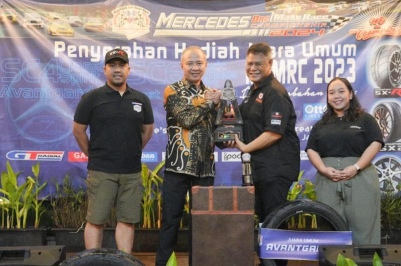 Tomi Hadi menyerahkan trofi juara umum MOMRC kepada M Yassin Kosasih, didampingi Bayu Putra Kesuma (GT Radial) dan Fairuz Nabilla Putri (Ottoban Tire)