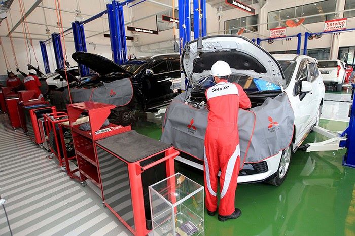 Mekanik Mitsubishi sementara melakukan perawatan terhadap mobil konsumen