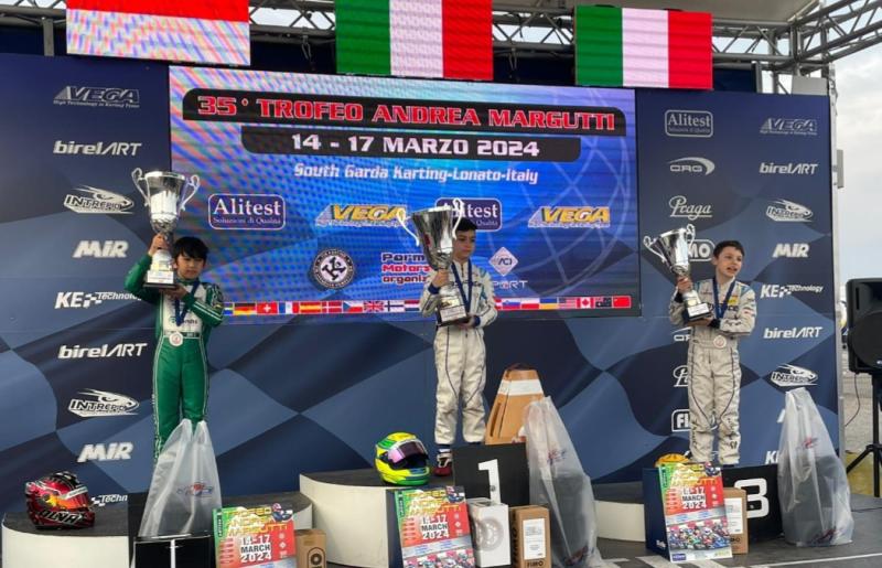 Oliver Rito Sini (kiri) di podium juara event gokart bertajuk Trofeo Andrea Margutti di sirkuit South Garda, Lonato, Italia, Minggu (17/3/2024)