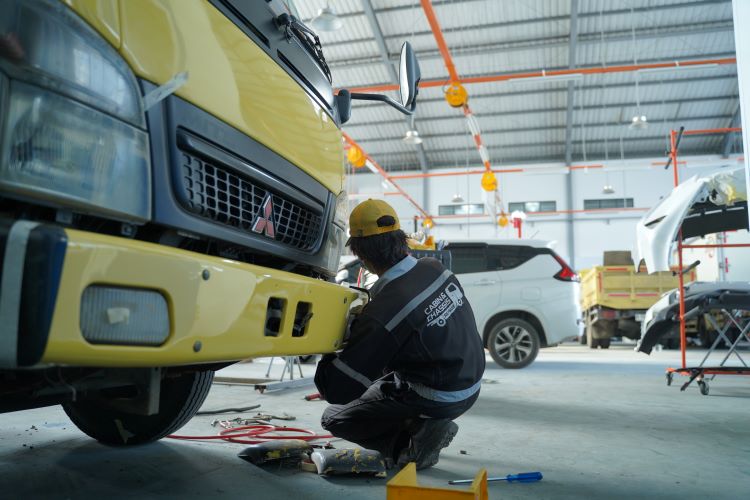 Mekanik Mitsubishi Fuso melakukan perbaikan dan perawatan truk konsumen 